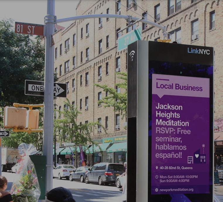LinkNYC kiosk on a New York City sidewalk displaying a local business ad